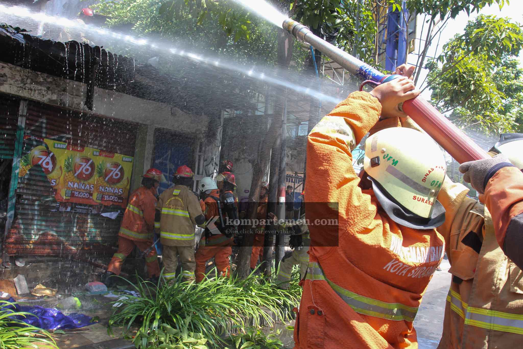 Petugas berusaha memadamkan api yang membakar satu unit rumah di Jalan Kertajaya 138, Surabaya, Minggu (28/7/2024). Dari penuturan saksi, api membumbung tinggi dari lantai 2 rumah tersebut.  Foto: Kompartemen.com/Bima Sakti