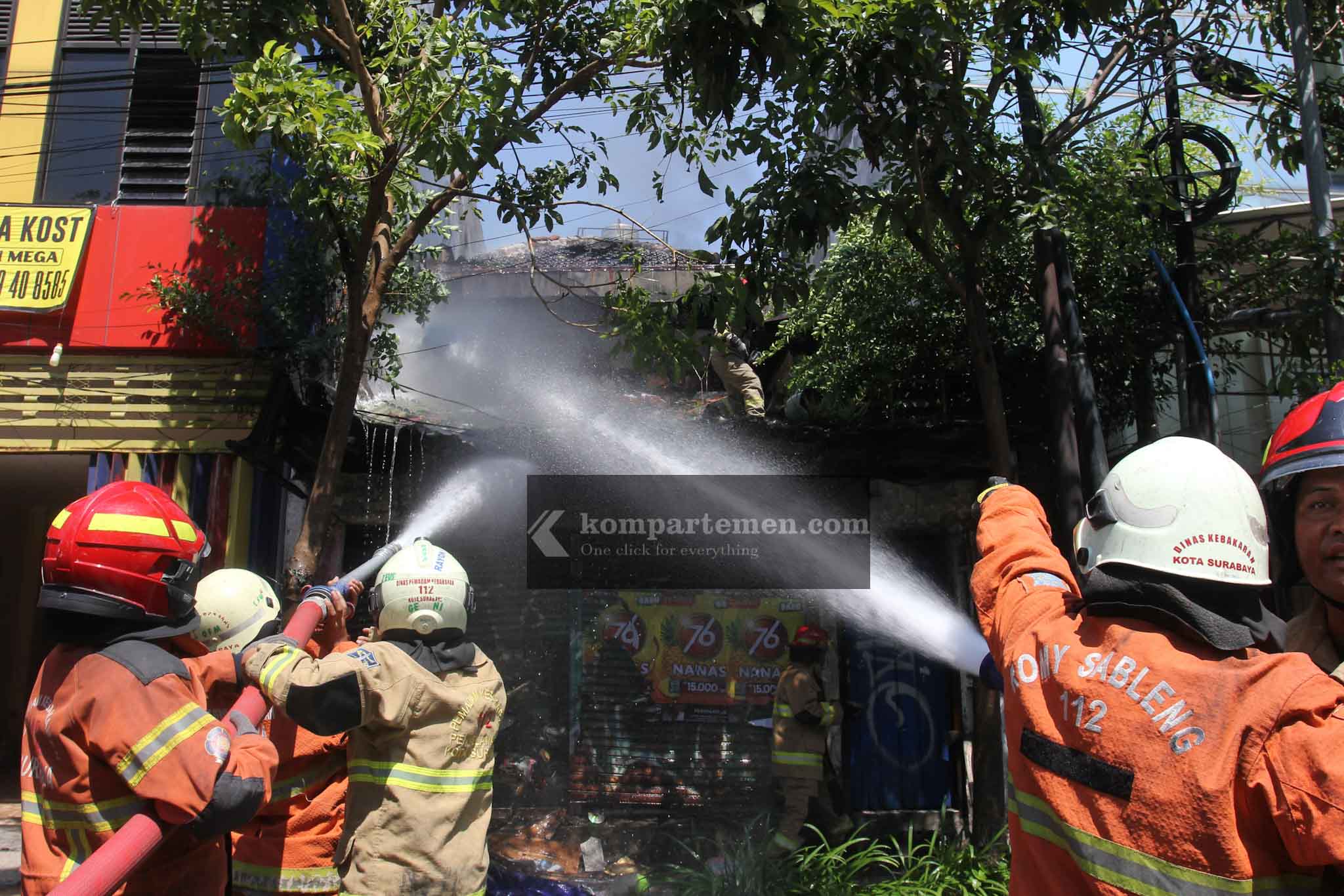 Kerja keras petugas dari Dinas Pemadam Kebakaran dan Keselamatan (DPKP) Surabaya dalam memadamkam api satu unit rumah di lantai 2 yang beralamat di Jalan Kertajaya 138 Surabaya, Minggu (28/7/2024) siang.  Diduga penyebab kebakaran karena arus pendek listrilk. Karena saat terjadi kebakaran lampu rumah masih tetap menyala. Foto: Kompartemen.com/Bima Sakti.