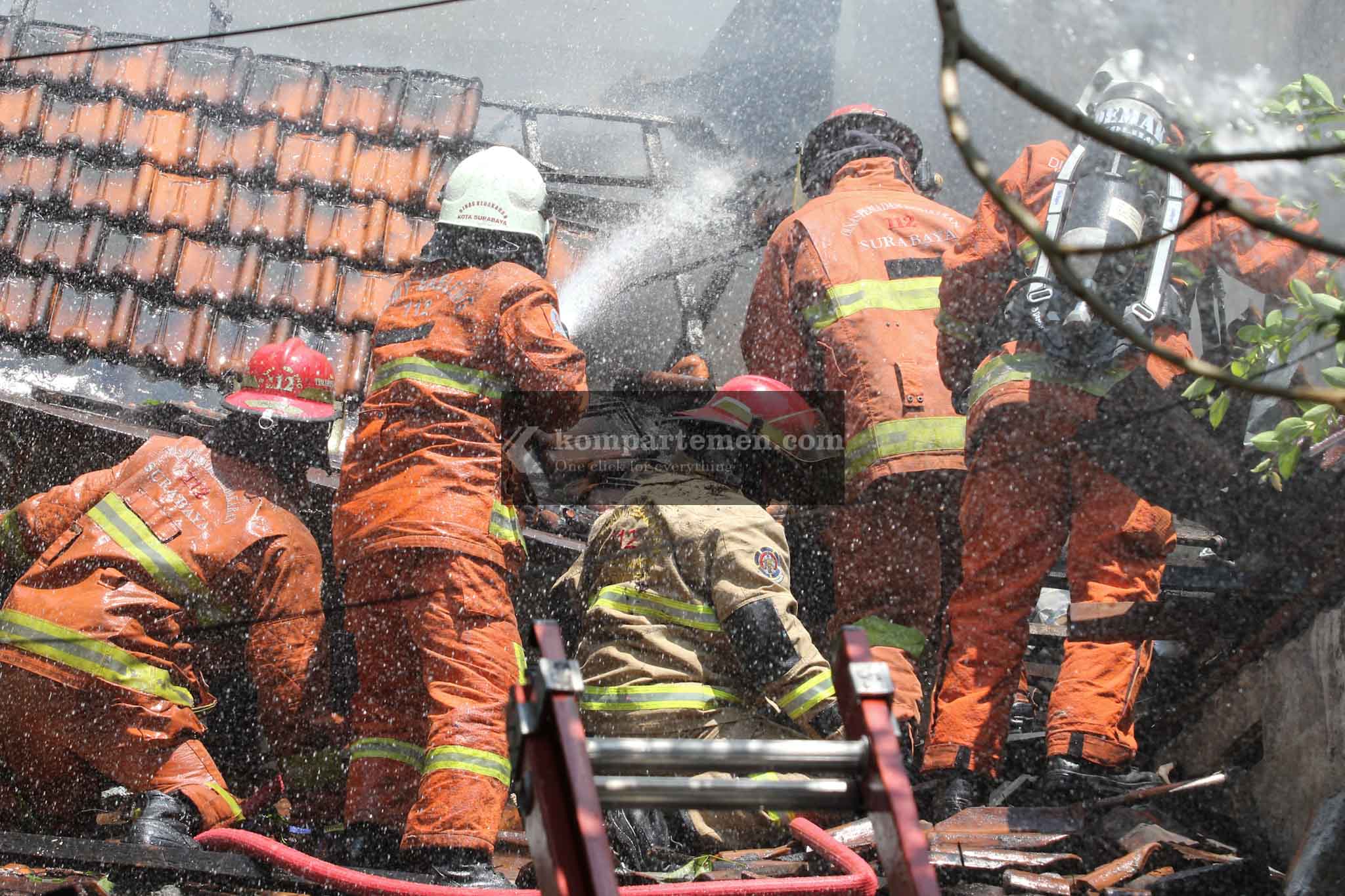 Petugas pemadam kebakaran mengalami pemadaman satu unit rumah di Jalan Kertajaya 138, Surabaya, dikarenakan banyak tumpukan barang bekas sehingga menutup akses ke lantai dua. Kebakaran tersebut terjadi Minggu (28/7/2024). Beruntung tidak ada korban jiwa dalam kebakaran tersebut. Foto: Kompartemen.com/Bima Sakti.